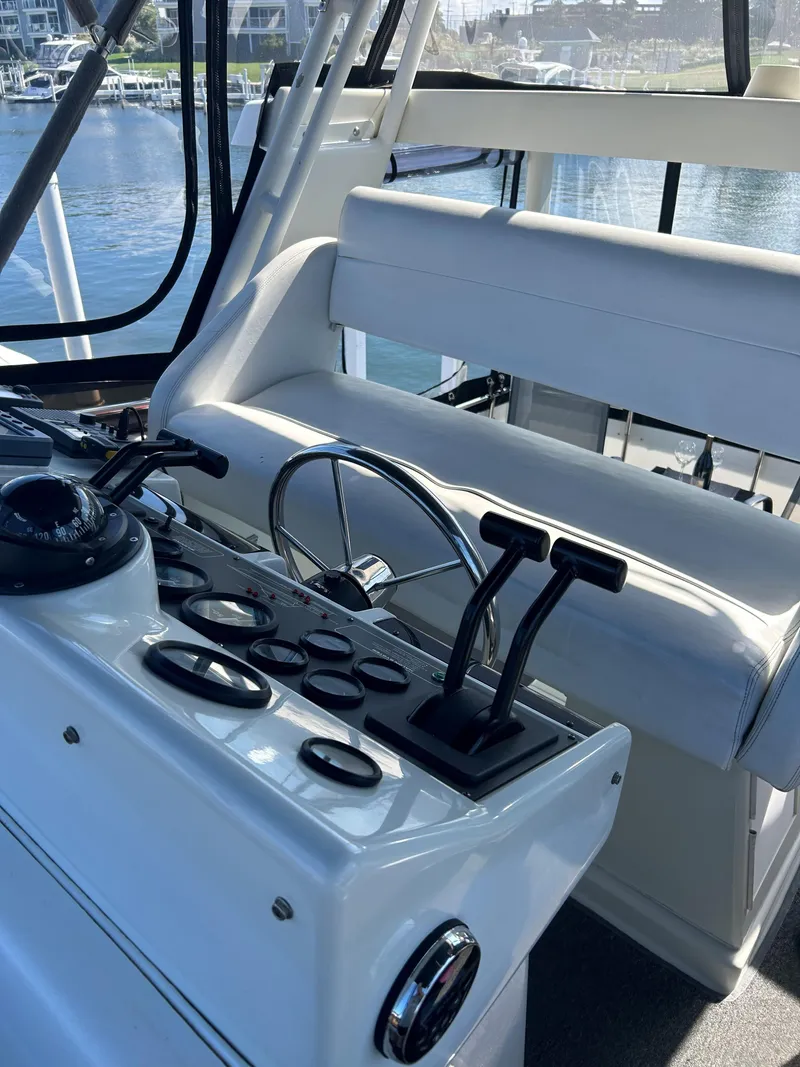 Slide: The Image of 1993 Silverton 34 Aft Cabin Motor Yacht helm with controls and seating. - 25