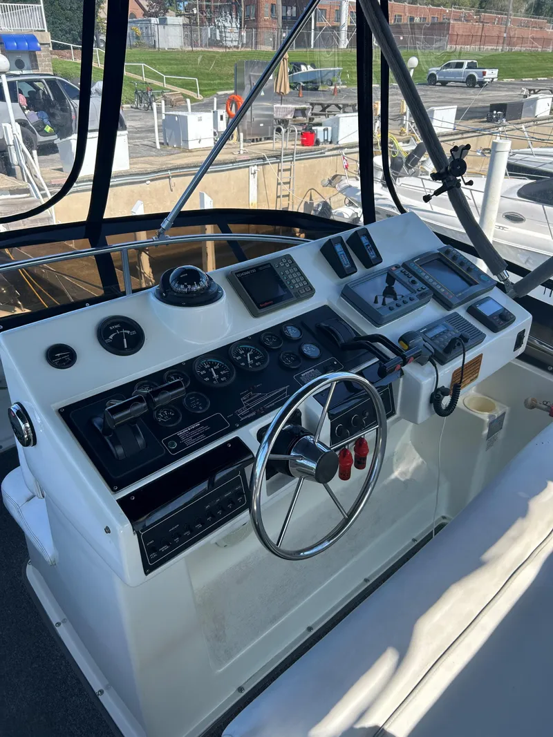 Slide: The Image of 1993 Silverton 34 Aft Cabin Motor Yacht helm with navigation instruments and steering wheel. - 26