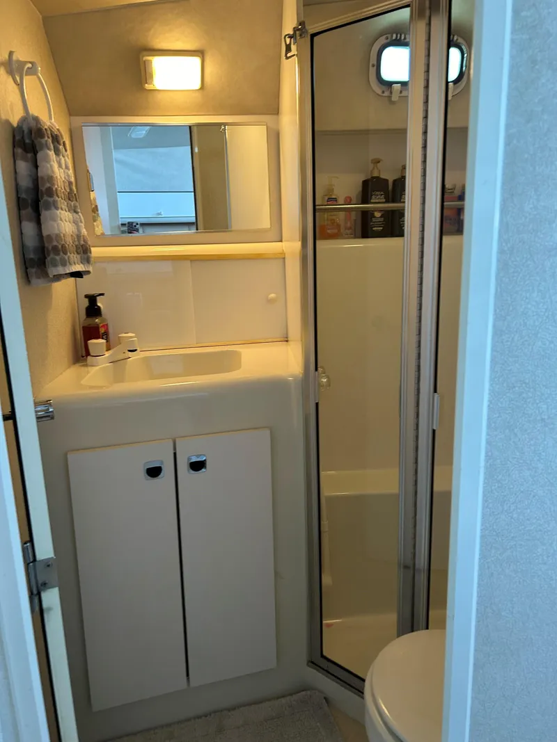 Slide: The Image of 1993 Silverton 34 Aft Cabin Motor Yacht bathroom with shower, sink, and storage. - 4