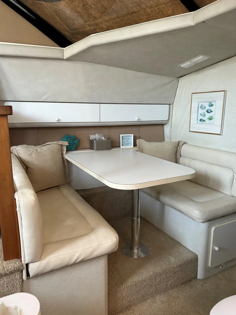 Slide: The Image of 1993 Silverton 34 Aft Cabin Motor Yacht interior with cozy dining area and cushioned seating. - 5