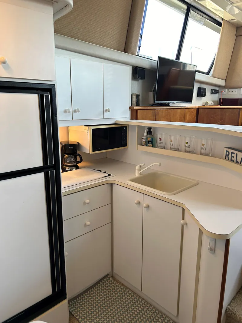 Slide: The Image of 1993 Silverton 34 Aft Cabin Motor Yacht kitchen with white cabinets and modern appliances. - 6