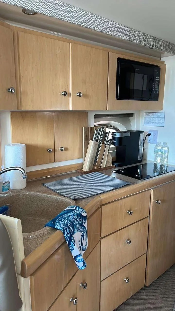 Slide: The Image of 1997 Carver 350 Mariner kitchen with wooden cabinets, sink, and microwave. - 13