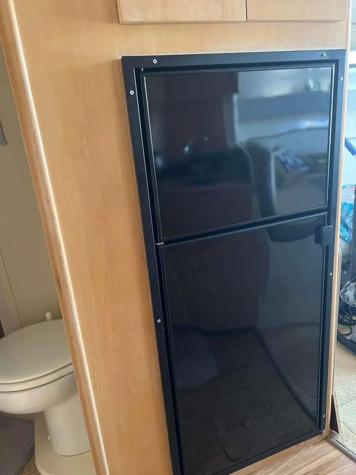 Slide: The Image of 1997 Carver 350 Mariner interior with black fridge and wooden cabinetry. - 15