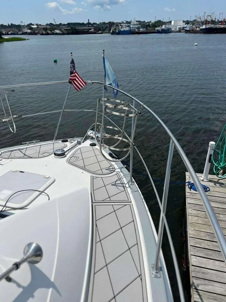 Slide: The Image of 1997 Carver 350 Mariner yacht docked by a serene waterfront. - 7