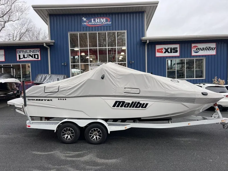 Slide: The Image of 2023 Malibu 23 LSV boat covered on trailer outside dealership. - 10