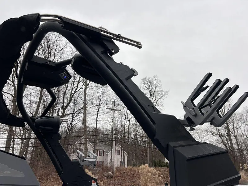 Slide: The Image of 2023 Malibu 23 LSV boat tower with wakeboard rack against a cloudy sky. - 16