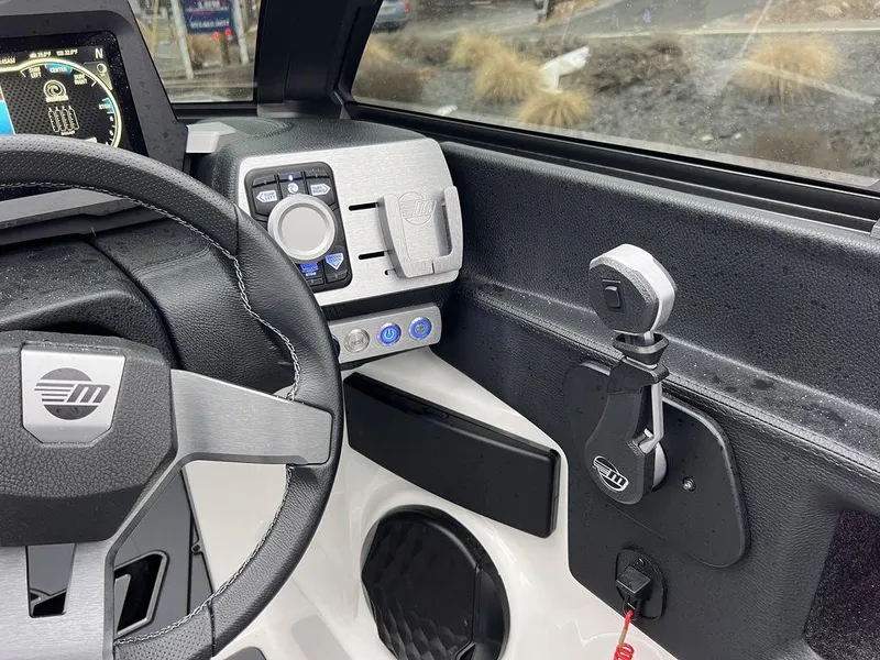 Slide: The Image of 2023 Malibu 23 LSV boat dashboard with steering wheel and control panel. - 21