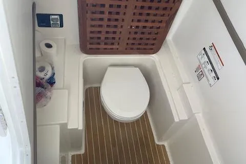 Slide: The Image of 2019 World Cat 320 DC boat bathroom with toilet and wooden floor. - 17