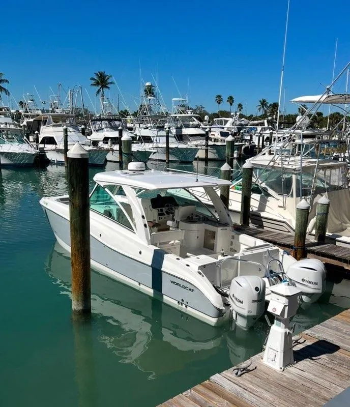 Slide: The Image of 2019 World Cat 320 DC boat docked in a marina with clear blue skies. - 3