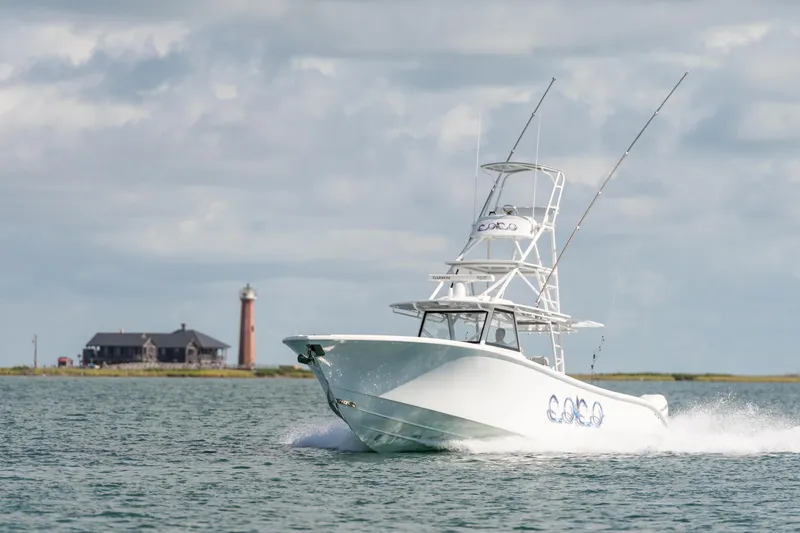 Slide: The Image of 2019 Yellowfin 42 Center Console boat cruising near a lighthouse. - 2