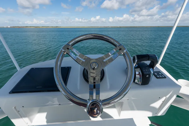 Slide: The Image of Steering wheel of 2019 Yellowfin 42 Center Console boat on open water. - 8