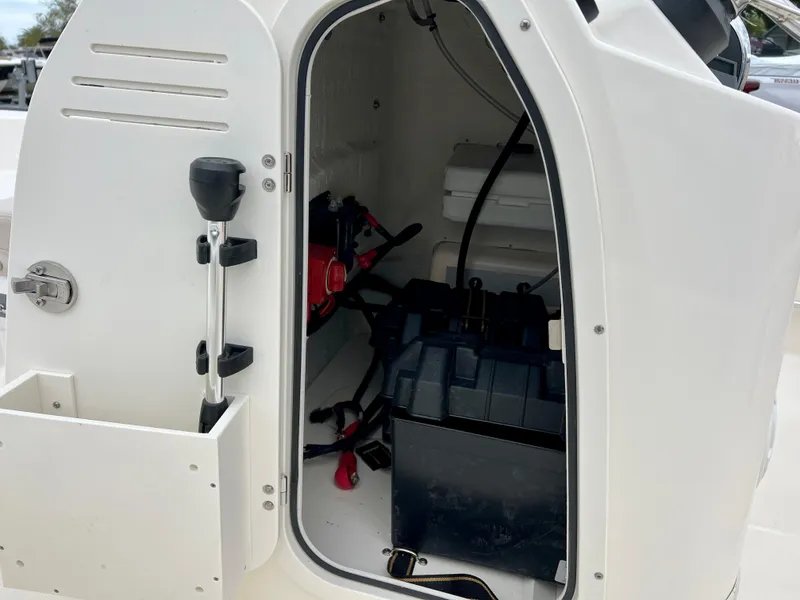 Slide: The Image of 2025 Boston Whaler 150 Montauk storage compartment with equipment and battery. - 11