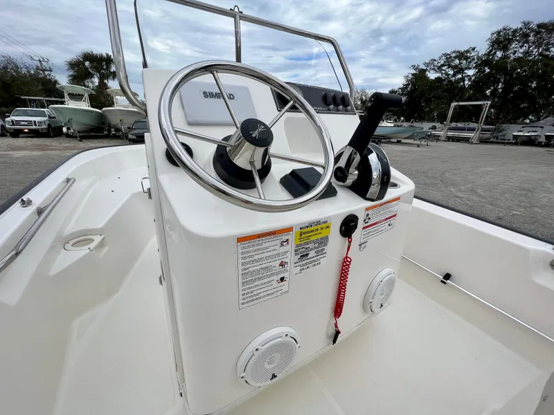Slide: The Image of 2025 Boston Whaler 150 Montauk boat console with steering wheel and controls. - 12