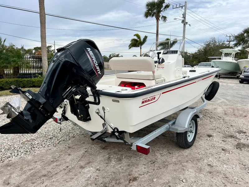 Slide: The Image of 2025 Boston Whaler 150 Montauk boat on trailer, featuring Mercury outboard motor. - 8