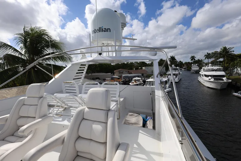 Slide: The Image of Luxurious 1988 Broward 124 Tri-Deck yacht with plush seating on a sunny day. - 15