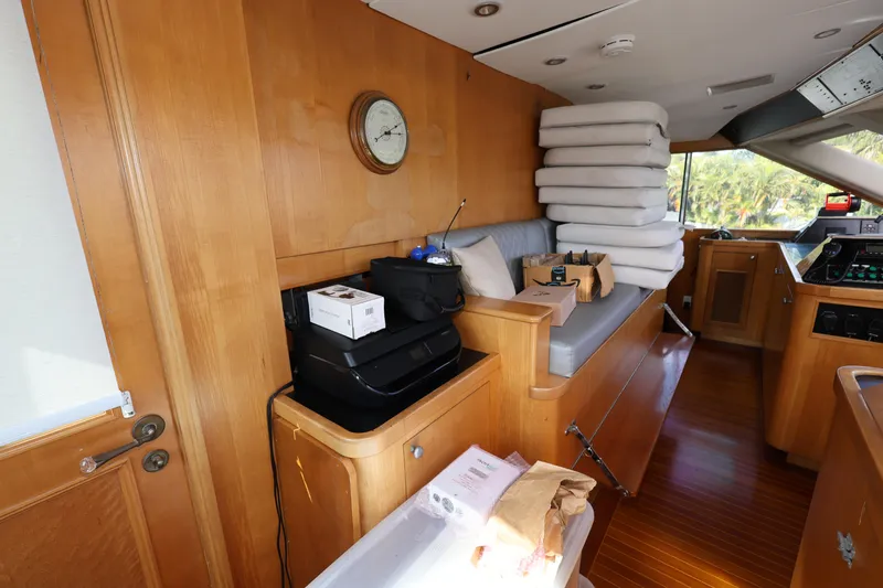 Slide: The Image of Interior of 1988 Broward 124 Tri-Deck MY yacht with wooden furnishings and stacked cushions. - 19