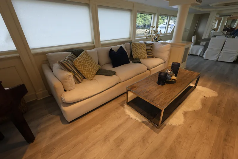 Slide: The Image of Luxurious 1988 Broward 124 Tri-Deck MY interior with elegant sofa and wooden coffee table. - 29