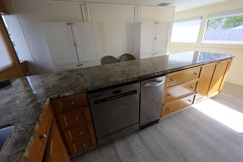 Slide: The Image of Spacious kitchen with granite countertops and wooden cabinets on a 1988 Broward 124 Tri-Deck MY. - 34