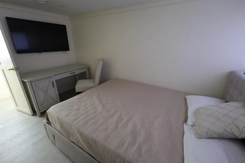 Slide: The Image of Bedroom interior of 1988 Broward 124 Tri-Deck MY yacht with bed, TV, and desk. - 35