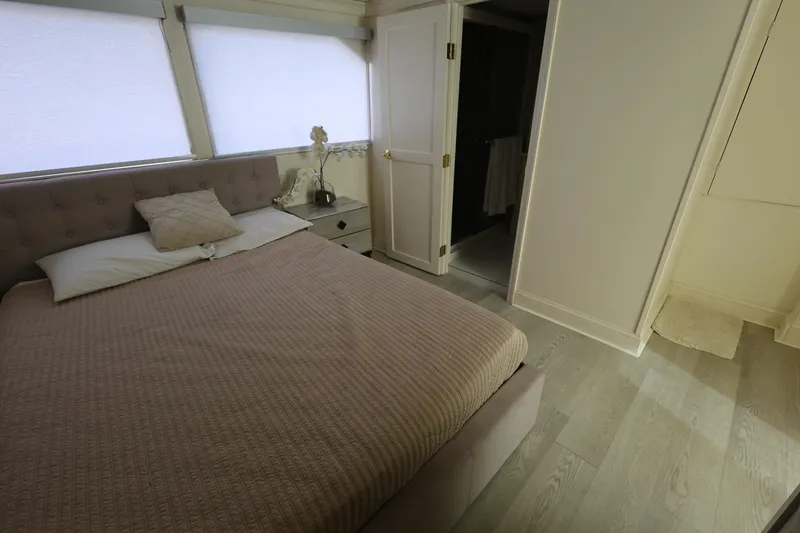 Slide: The Image of Bedroom interior of 1988 Broward 124 Tri-Deck MY yacht, featuring a cozy bed and modern decor. - 36