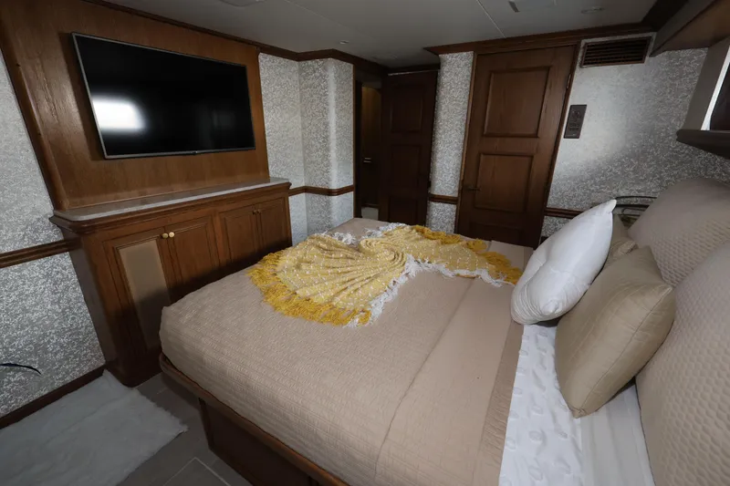 Slide: The Image of Luxurious bedroom in 1988 Broward 124 Tri-Deck MY yacht with TV and elegant decor. - 37