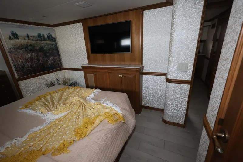 Slide: The Image of Luxurious bedroom interior of 1988 Broward 124 Tri-Deck MY yacht with TV and elegant decor. - 39