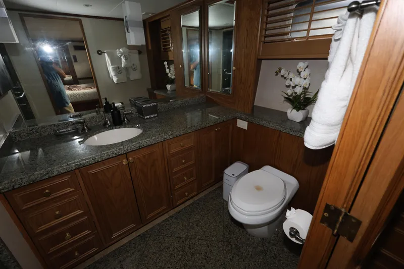Slide: The Image of Luxurious bathroom in 1988 Broward 124 Tri-Deck MY yacht with granite countertops and wooden cabinetry. - 43