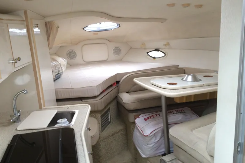 Slide: The Image of 2000 Maxum 2800 SCR cabin interior with bed, kitchenette, and dining area. - 15