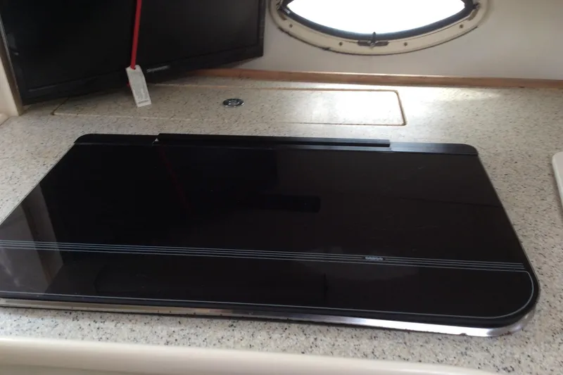 Slide: The Image of 2000 Maxum 2800 SCR boat interior with sleek black cooktop on countertop. - 20