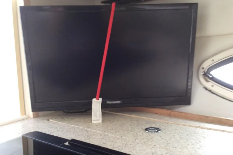 Slide: The Image of Flat-screen TV secured with a red strap inside a 2000 Maxum 2800 SCR boat. - 25