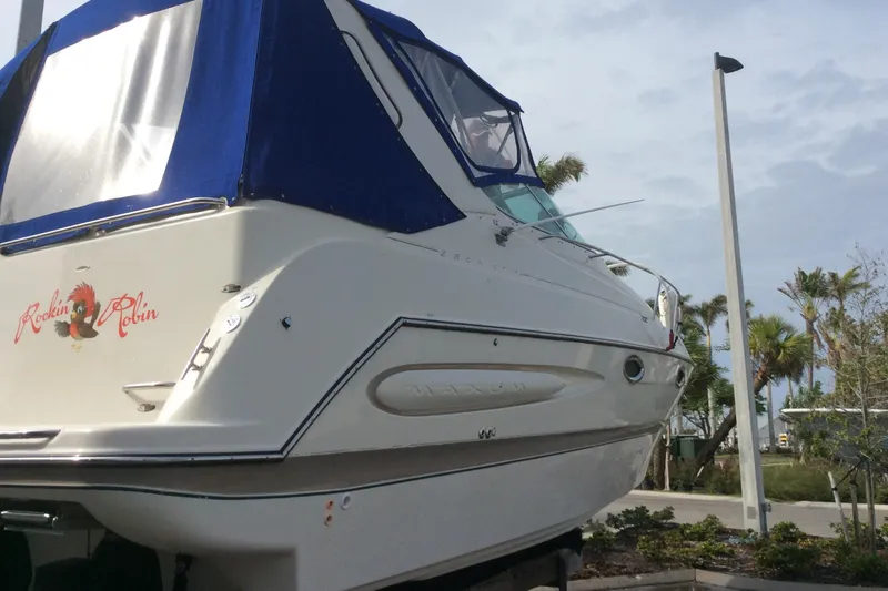 Slide: The Image of 2000 Maxum 2800 SCR boat with blue canopy, docked outdoors. - 3