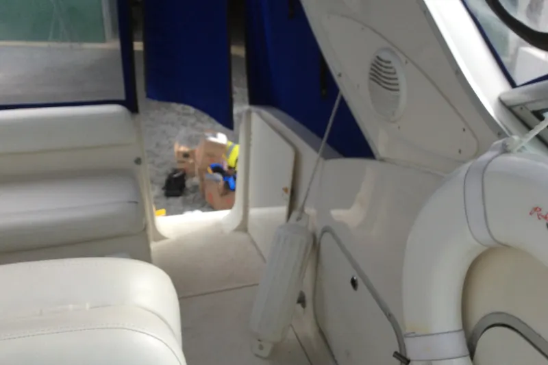 Slide: The Image of Interior view of a 2000 Maxum 2800 SCR boat with white seating and blue curtains. - 8