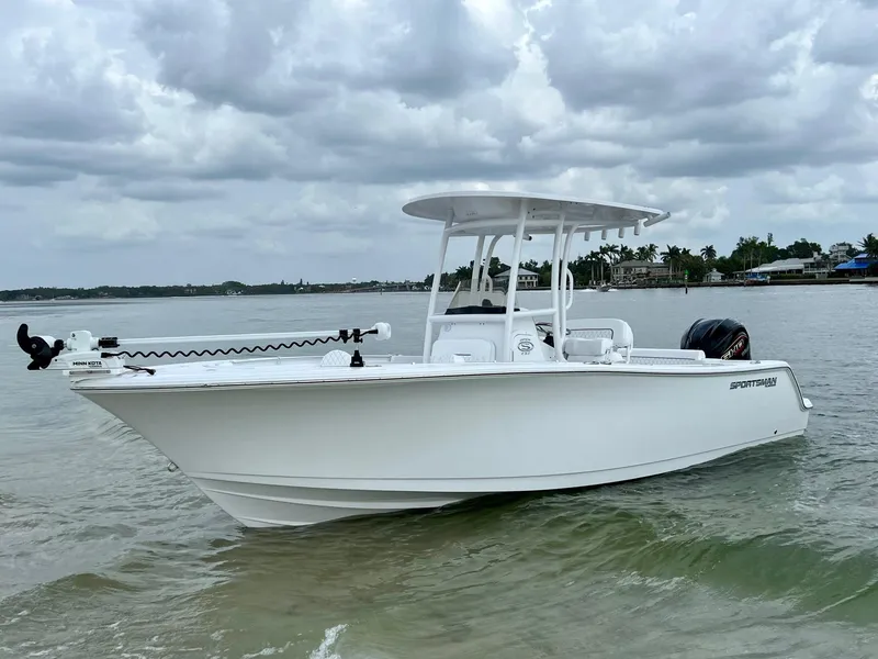 Slide: The Image of 2023 Sportsman Open 232 Center Console boat on calm water under cloudy sky. - 1