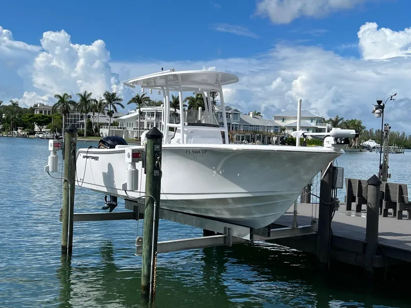 Slide: The Image of 2023 Sportsman Open 232 Center Console boat docked by waterfront homes. - 3
