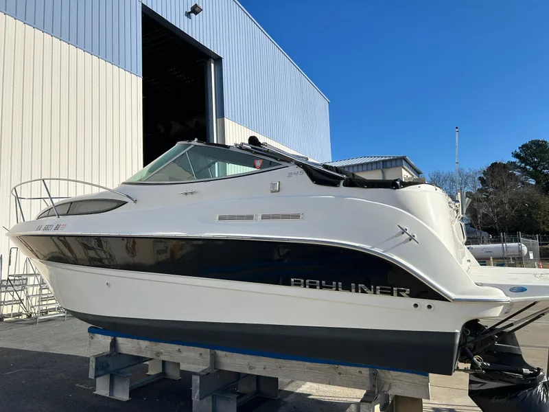 Slide: The Image of 2013 Bayliner 245 Cruiser boat on display outside a warehouse. - 1