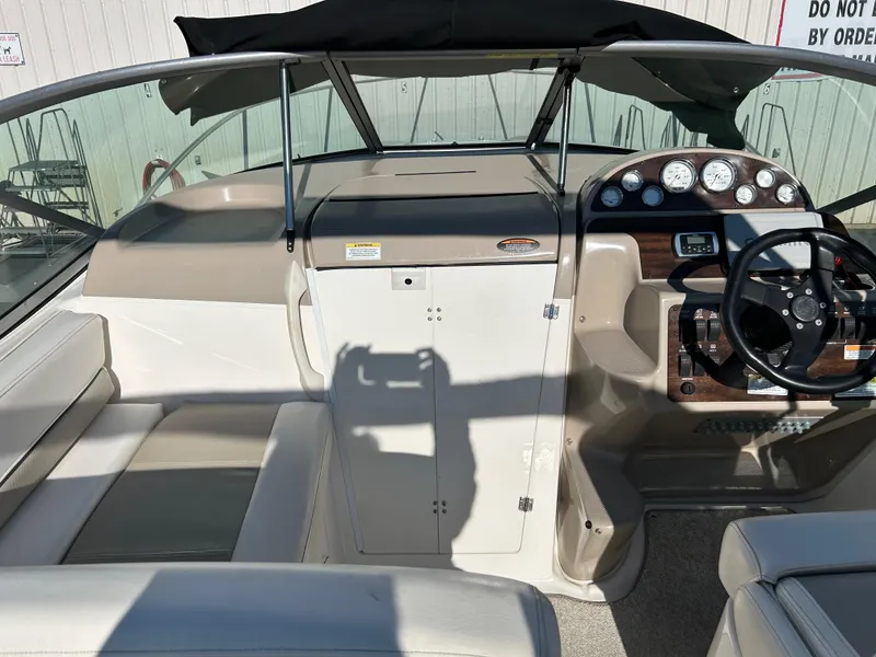 Slide: The Image of 2013 Bayliner 245 Cruiser interior with steering console and seating area. - 11