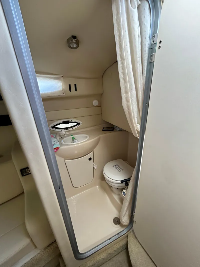 Slide: The Image of 2013 Bayliner 245 Cruiser bathroom with sink, toilet, and shower curtain. - 13