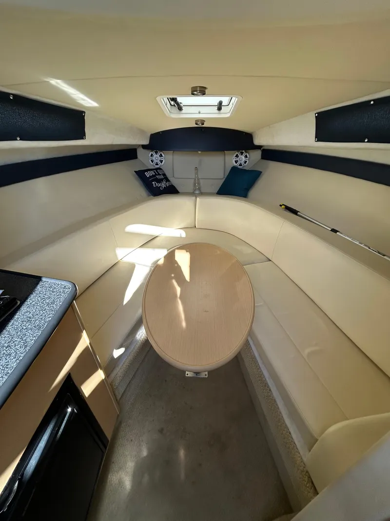 Slide: The Image of Interior of 2013 Bayliner 245 Cruiser with beige seating and compact cabin layout. - 15