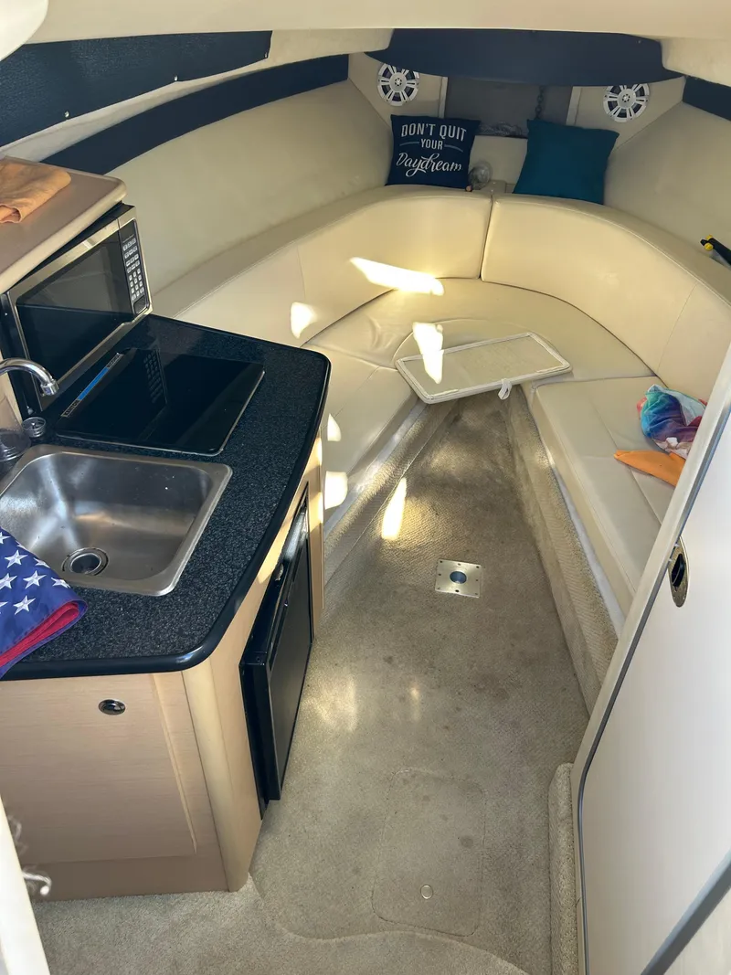 Slide: The Image of Interior of 2013 Bayliner 245 Cruiser with kitchenette and seating area. - 7