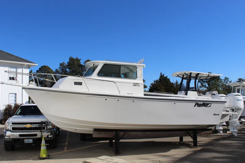 The Image of 2025 Parker 2520 boat on display, parked outdoors under clear blue sky. - 0