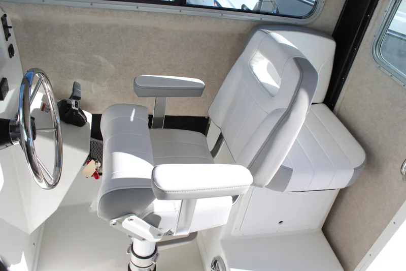 Slide: The Image of Interior of 2025 Parker 2520 boat with steering wheel and cushioned seats. - 4