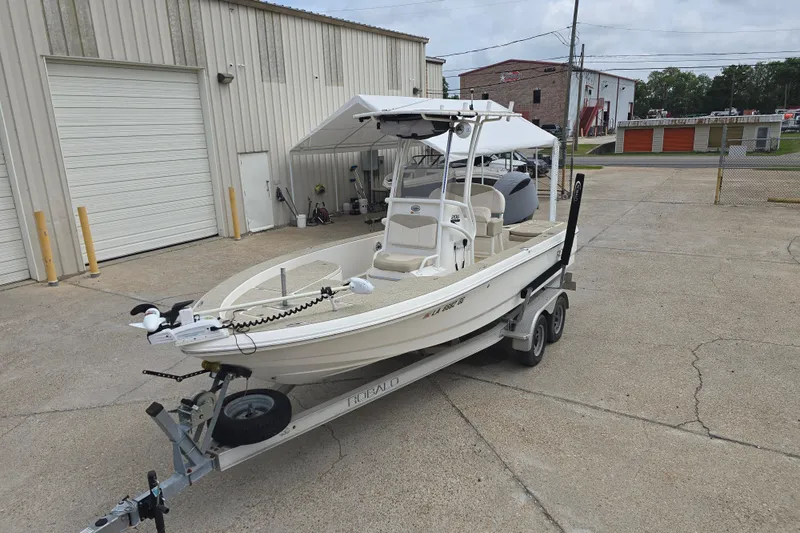 Slide: The Image of 2017 Robalo 206 Cayman boat on trailer outside a warehouse. - 13