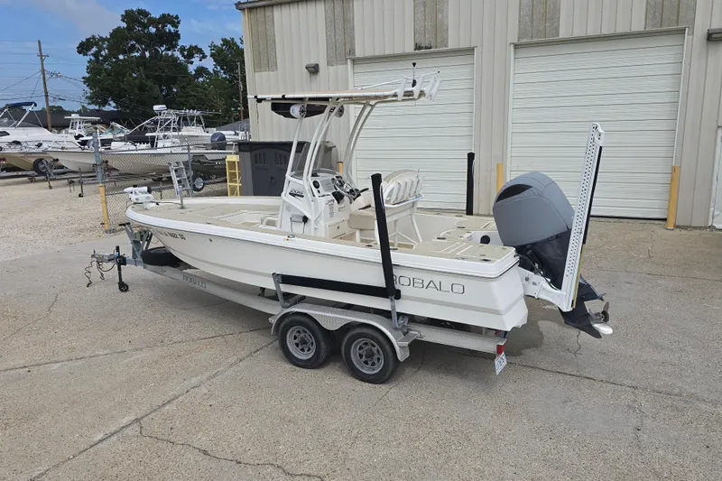 Slide: The Image of 2017 Robalo 206 Cayman boat on trailer, parked outside a warehouse. - 14
