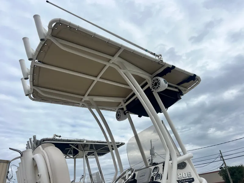 Slide: The Image of 2017 Robalo 206 Cayman boat with T-top and speakers under cloudy sky. - 4