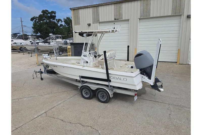 Slide: The Image of 2017 Robalo 206 Cayman boat on trailer, parked outside a warehouse. - 9