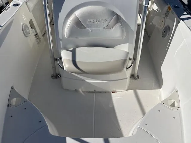 Slide: The Image of 2004 Boston Whaler 240 Outrage boat interior, featuring seating and clean white deck. - 11