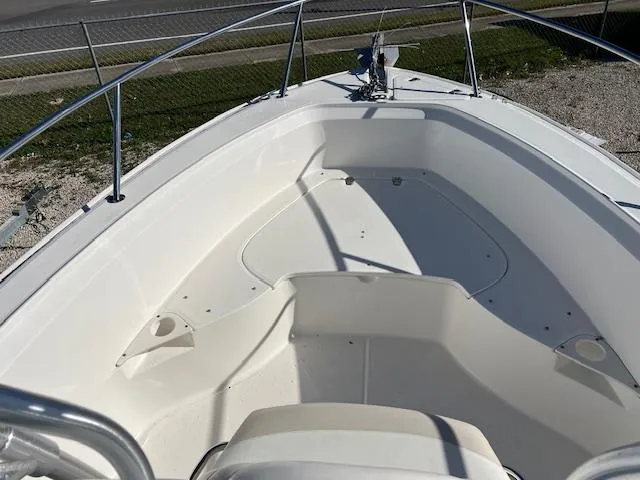 Slide: The Image of 2004 Boston Whaler 240 Outrage boat interior, white seating and deck, sunny day. - 9