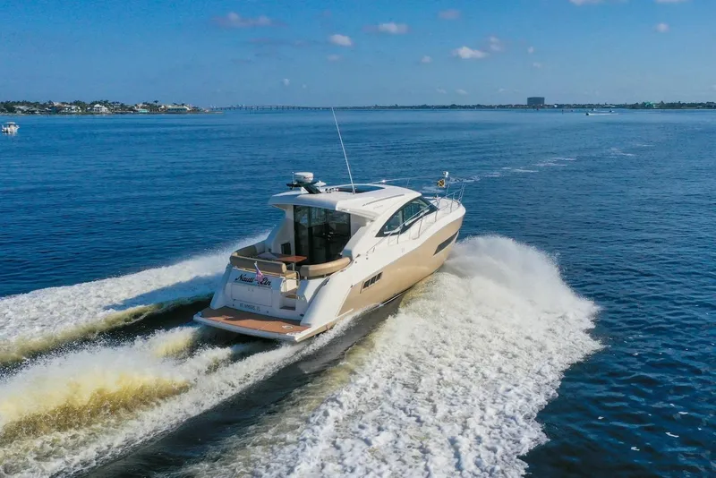 Slide: The Image of 2016 Carver C37 Coupe cruising on open water, creating a dynamic wake. - 2
