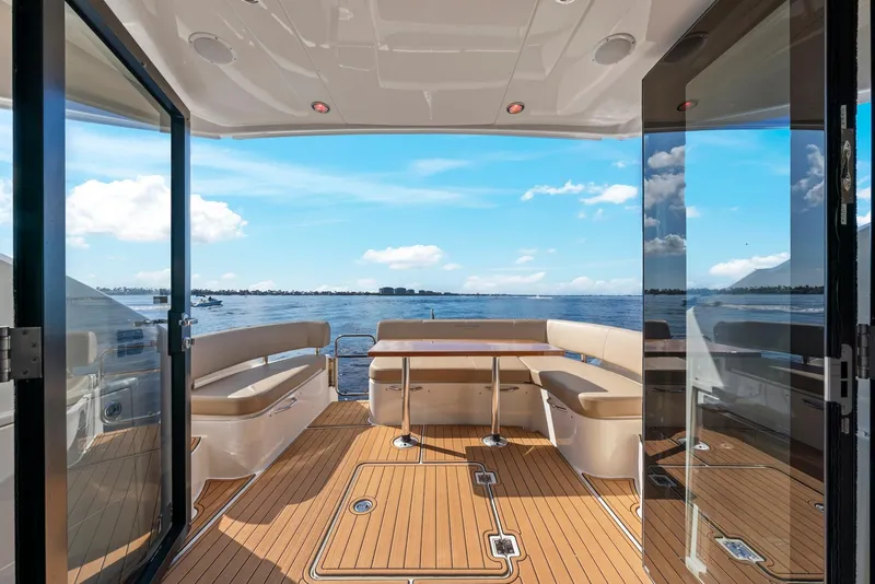 Slide: The Image of 2016 Carver C37 Coupe yacht interior with ocean view, featuring elegant seating and wooden flooring. - 29