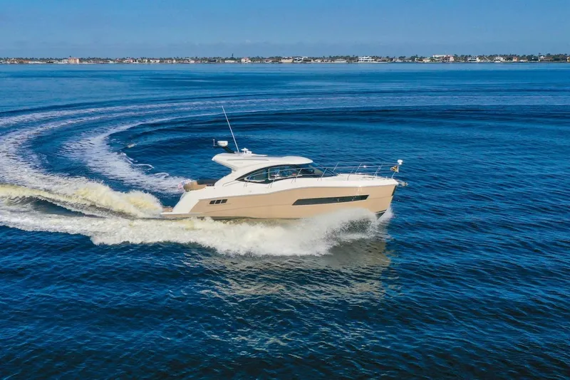 Slide: The Image of 2016 Carver C37 Coupe yacht cruising on open water, creating a wake. - 3